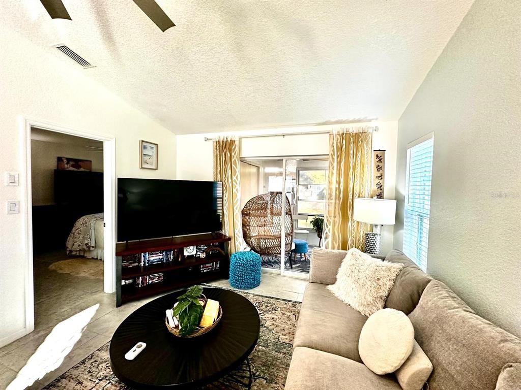 4749 Sunny Loop, Unit 4749 Holiday, FL 34690 - Photo 13 of 34 a living room with furniture and a flat screen tv