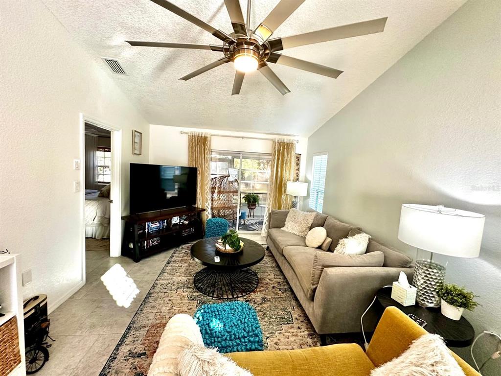 4749 Sunny Loop, Unit 4749 Holiday, FL 34690 - Photo 14 of 34 a living room with furniture a flat screen tv and a large window