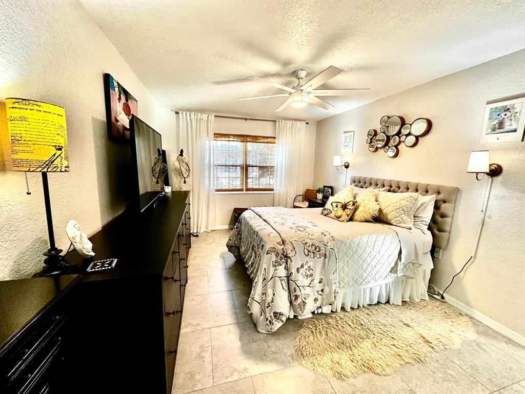 4749 Sunny Loop, Unit 4749 Holiday, FL 34690 - Photo 16 of 34 a bedroom with a bed and a flat tv screen on dresser