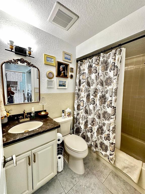 4749 Sunny Loop, Unit 4749 Holiday, FL 34690 - Photo 21 of 34 a bathroom with a granite countertop sink toilet and shower
