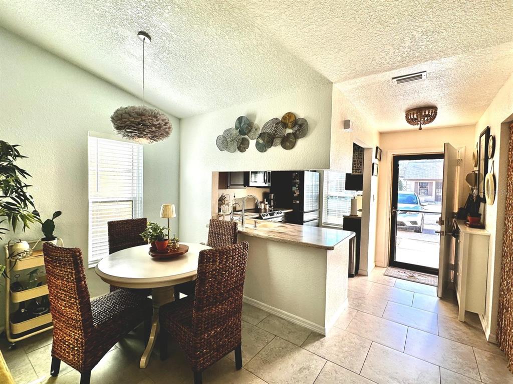 4749 Sunny Loop, Unit 4749 Holiday, FL 34690 - Photo 3 of 34 a kitchen with a dining table cabinets and a counter top space