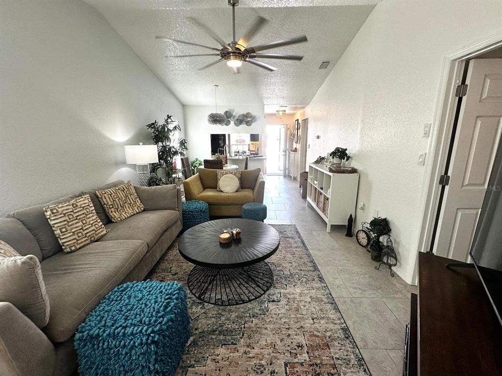 4749 Sunny Loop, Unit 4749 Holiday, FL 34690 - Photo 8 of 34 a living room with furniture a rug and a chandelier