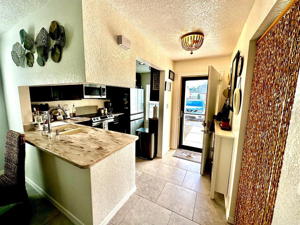 4749 Sunny Loop, Unit 4749 Holiday, FL 34690 - Photo 10 of 34 a kitchen with a refrigerator and a sink