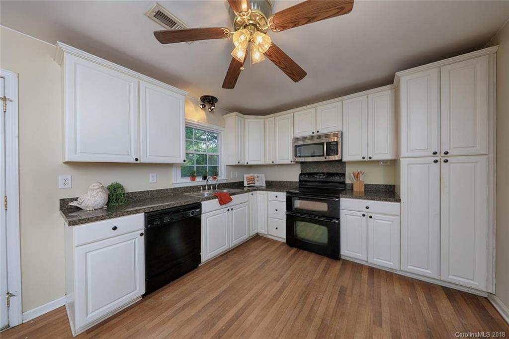 3327 Woodleaf Road Charlotte, NC 28205 - Photo 11 of 36 a kitchen with granite countertop stainless steel appliances and wooden cabinets