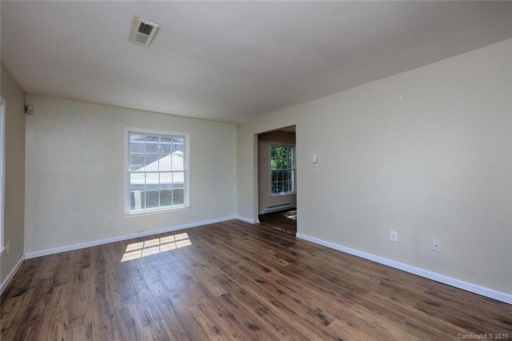 3327 Woodleaf Road Charlotte, NC 28205 - Photo 5 of 36 an empty room with wooden floor and windows