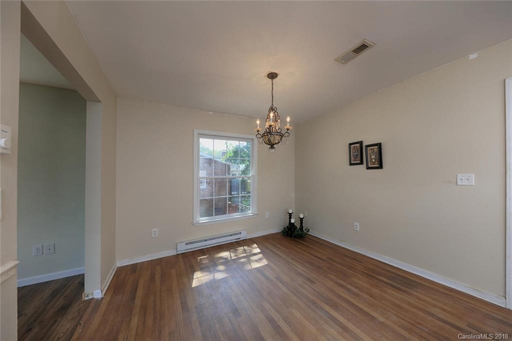 3327 Woodleaf Road Charlotte, NC 28205 - Photo 8 of 36 an empty room with wooden floor chandelier and windows