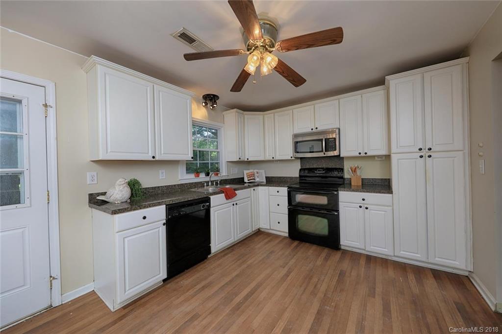 3327 Woodleaf Road Charlotte, NC 28205 - Photo 10 of 36 a kitchen with granite countertop stainless steel appliances and wooden cabinets