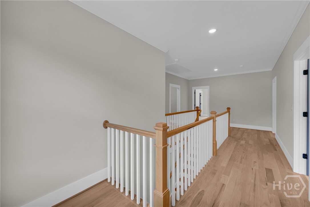 2476 St Martin Way Monroe, GA 30656 - Photo 33 of 75 Upper-level hallway featuring wood-finish flooring, white baluster railing with wood newel posts, recessed lighting, and panel doors with dark hardware