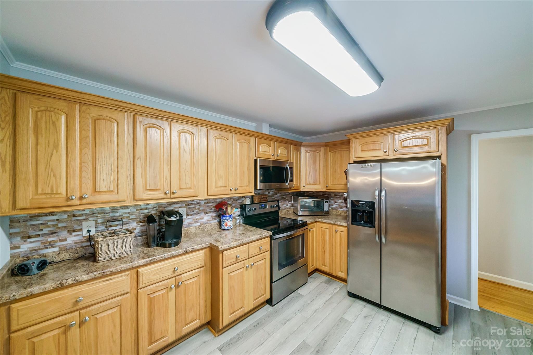 292 Welch Road Lansing, NC 28643 - Photo 15 of 47 a kitchen with stainless steel appliances granite countertop a refrigerator a sink dishwasher a stove and white cabinets with wooden floor