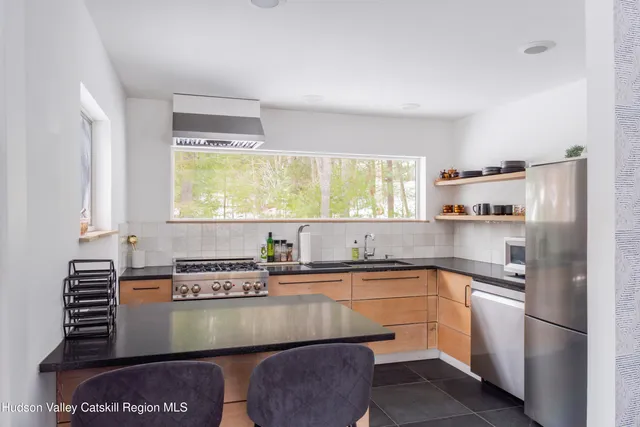 a kitchen with stainless steel appliances granite countertop a sink a stove and a refrigerator