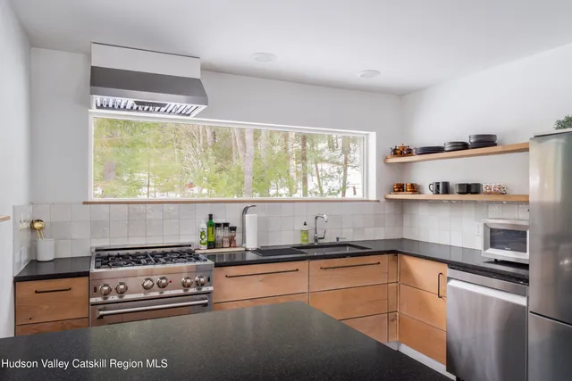 a kitchen with stainless steel appliances granite countertop a sink stove and window