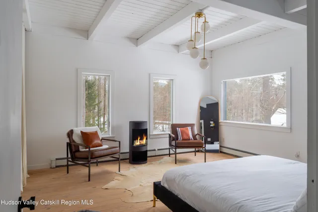 a bedroom with a large bed a chandelier and windows