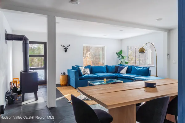a living room with furniture a large window and wooden floor