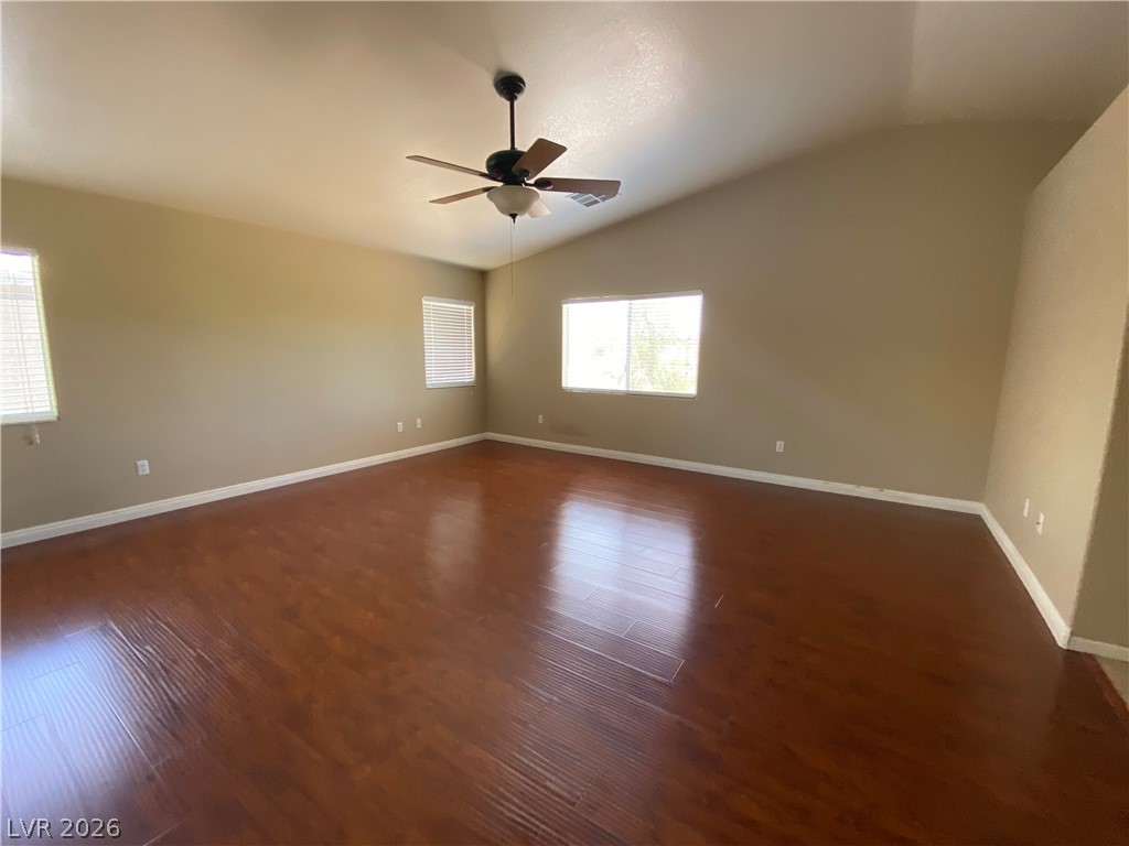 489 Foster Springs Road Las Vegas, NV 89148 - Photo 13 of 30 An inviting room features rich hardwood flooring and a vaulted ceiling with a prominent ceiling fan.