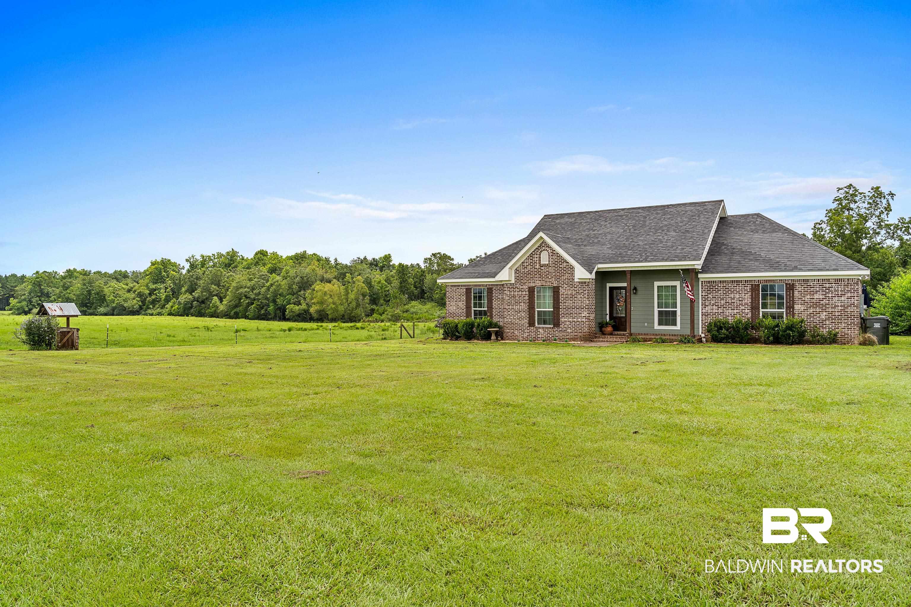 25212 Reeves Lane Elberta, AL 36530 - Photo 2 of 28 View of front of home featuring brick siding, a front lawn, roof with shingles, and a rural view