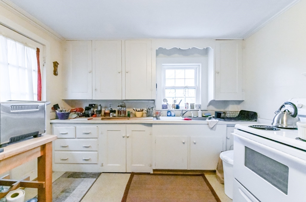 436 High Street Walpole, MA 02081 - Photo 41 of 42 a kitchen with granite countertop a sink stove and cabinets
