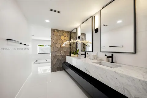 a bathroom with double vanity and a bathtub