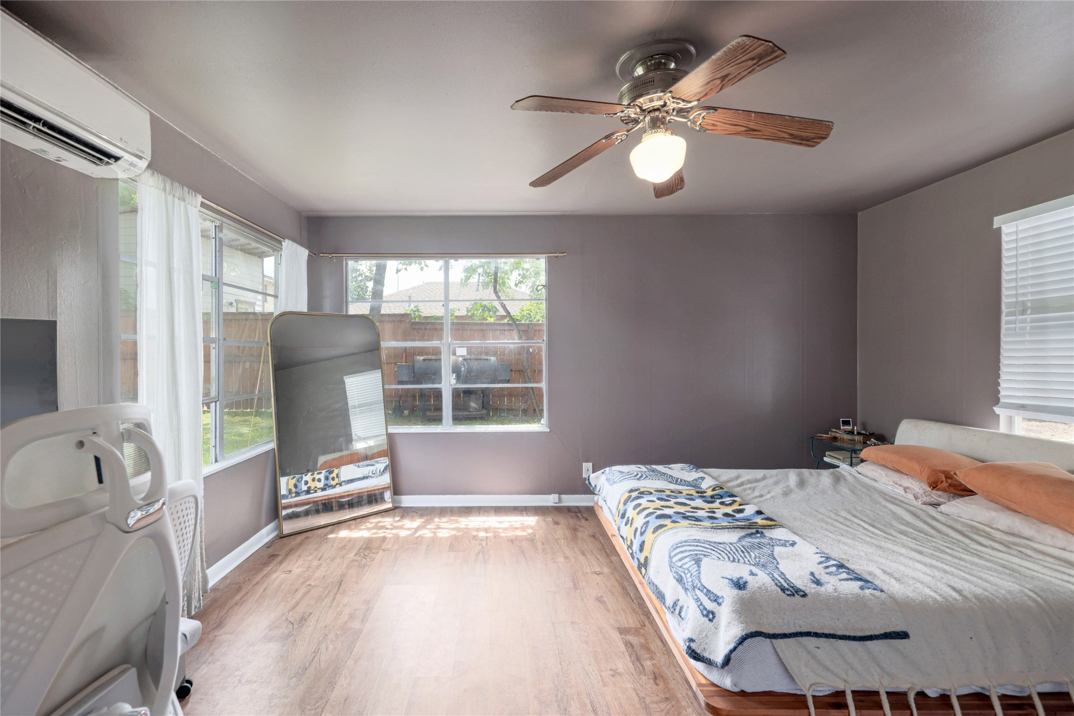 4607 Evans Avenue, Unit B Austin, TX 78751 - Photo 10 of 34 Spacious interior featuring wood-finish flooring, a ceiling fan with light fixture, and multiple windows providing natural light