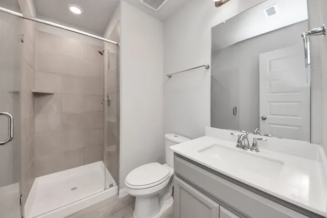a bathroom with a granite countertop sink a toilet and shower