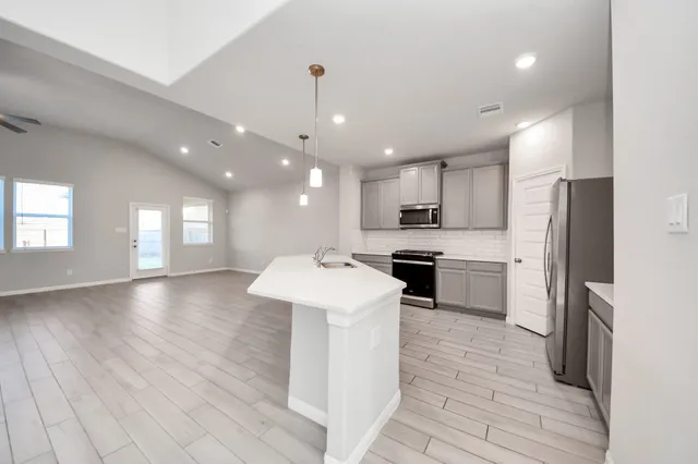 a kitchen with a sink stainless steel appliances furniture cabinets and a counter top space