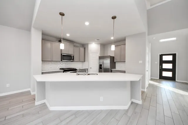 a view of kitchen with sink microwave and refrigerator