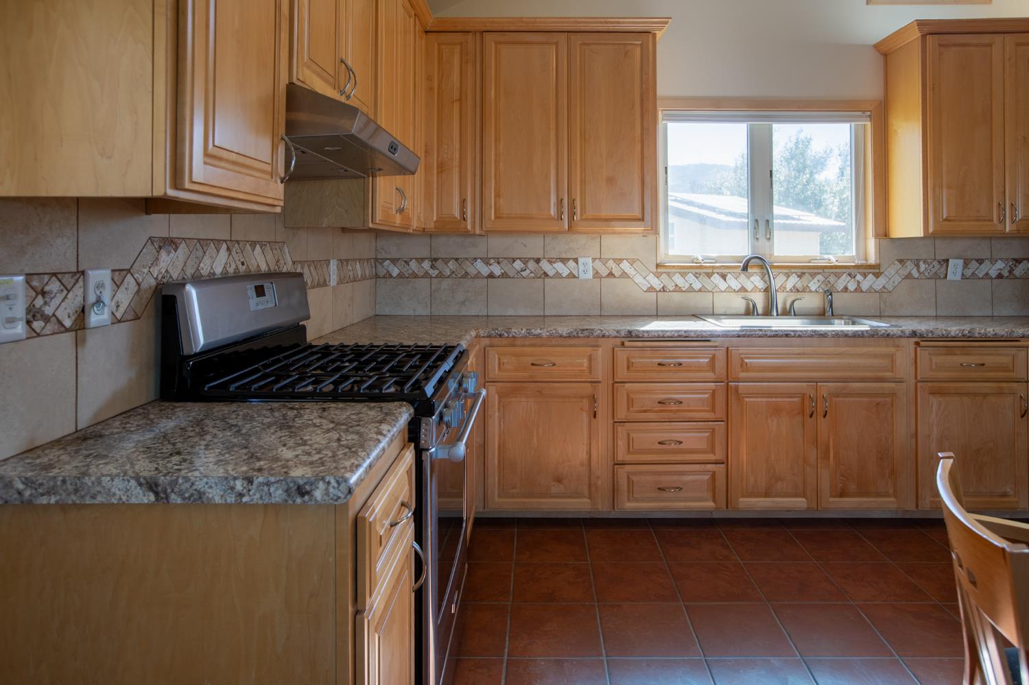 44981 Todd Eymann Road Dunlap, CA 93621 - Photo 18 of 74 a kitchen with stainless steel appliances granite countertop a sink stove and cabinets