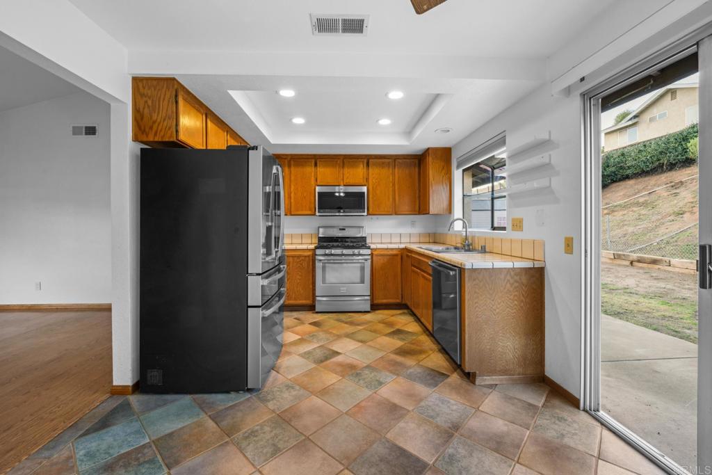 10254 Princess Joann Road Santee, CA 92071 - Photo 13 of 41 a kitchen with stainless steel appliances granite countertop a refrigerator and a sink