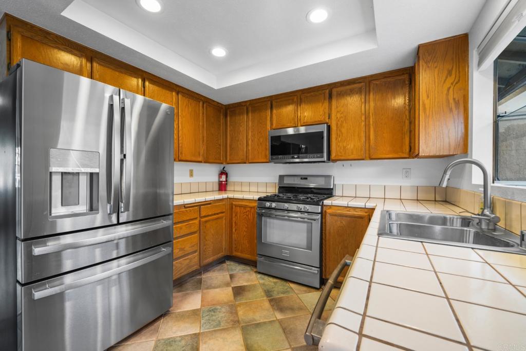 10254 Princess Joann Road Santee, CA 92071 - Photo 4 of 41 a kitchen with stainless steel appliances granite countertop a refrigerator sink and stove