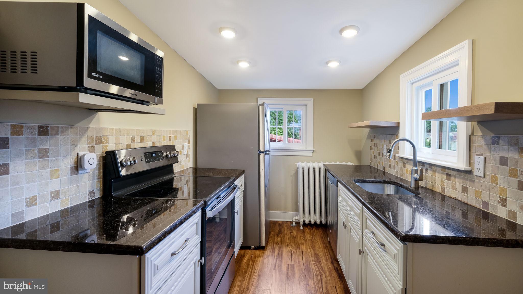 112 East State Street, Unit 6 Doylestown, PA 18901 - Photo 4 of 13 a kitchen with granite countertop a stove and a sink