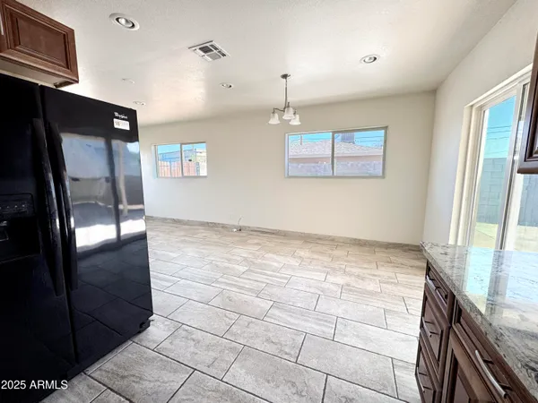 a kitchen with stainless steel appliances granite countertop a refrigerator and a stove top oven