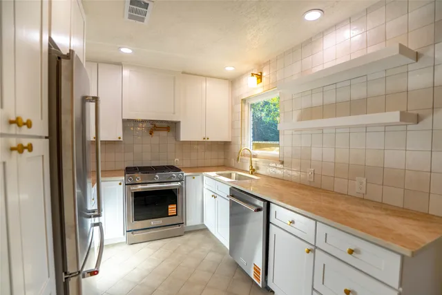 a kitchen with a sink cabinets and stainless steel appliances