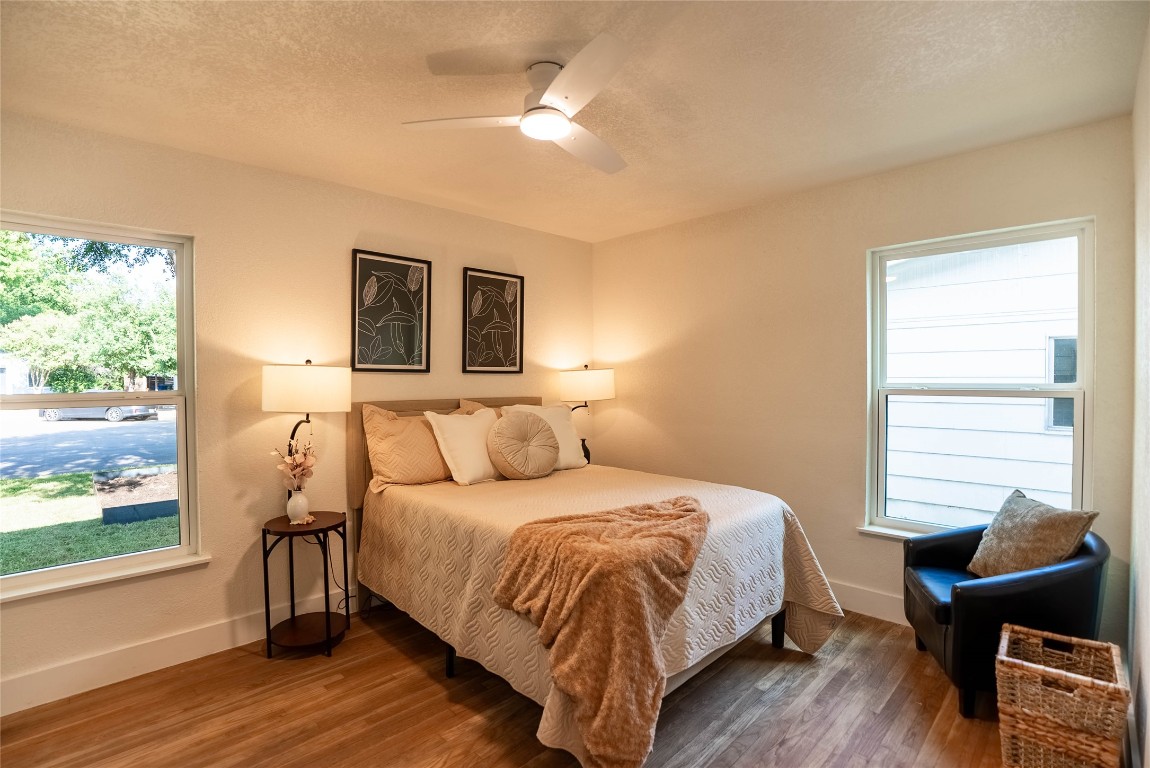 7700 Robalo Road Austin, TX 78757 - Photo 13 of 23 a bedroom with a bed and wooden floor