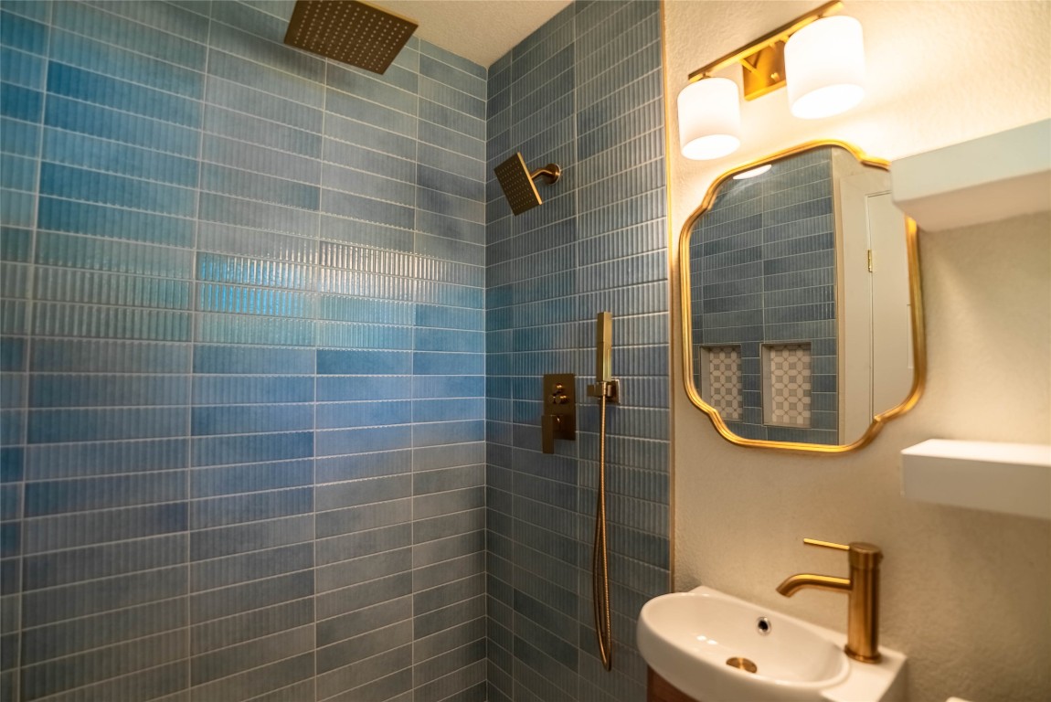 7700 Robalo Road Austin, TX 78757 - Photo 15 of 23 a bathroom with a sink a mirror and a shower