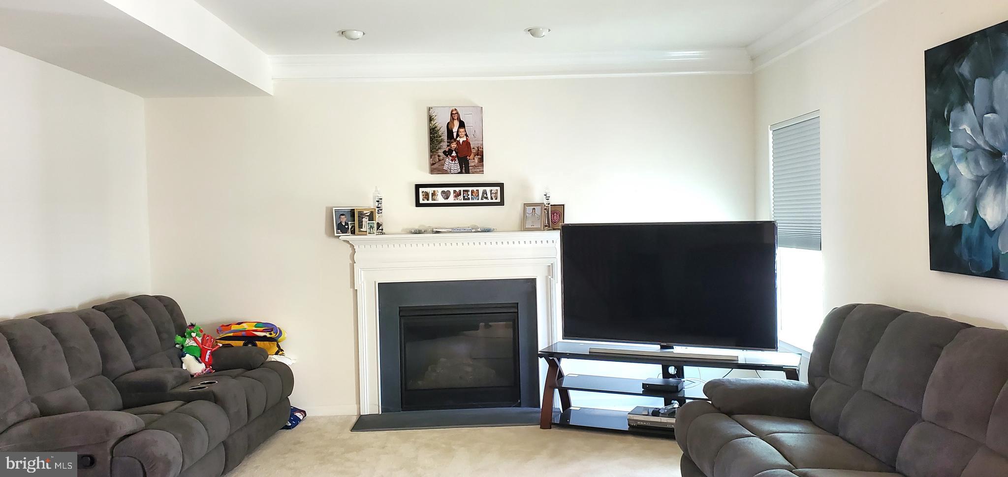 1999 Crossings Way Quakertown, PA 18951 - Photo 4 of 30 a living room with furniture a flat screen tv and a fireplace