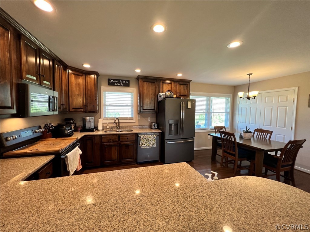 1214 Wilson Road Wilsons, VA 23894 - Photo 9 of 41 a kitchen with stainless steel appliances kitchen island granite countertop a refrigerator a sink a stove a dining table and chairs