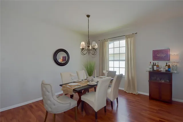 a living room with furniture a dining table and wooden floor