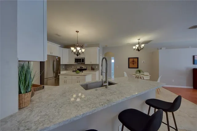 a kitchen with stainless steel appliances granite countertop a sink and a refrigerator