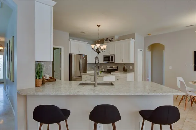 a kitchen with stainless steel appliances granite countertop a sink refrigerator and cabinets