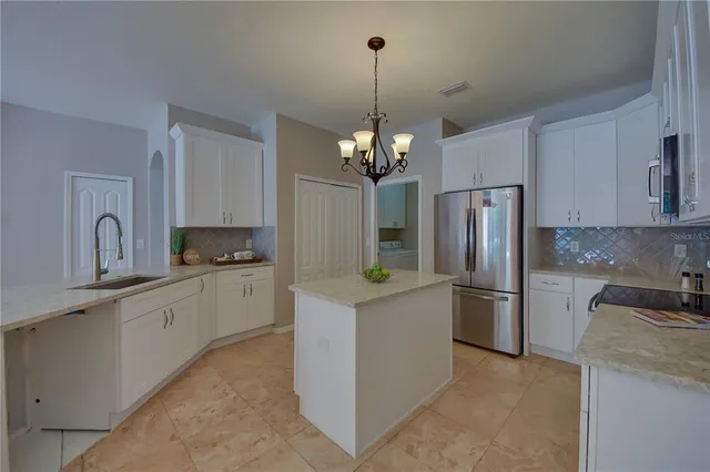 a kitchen with stainless steel appliances granite countertop a sink a stove top oven a counter space and cabinets