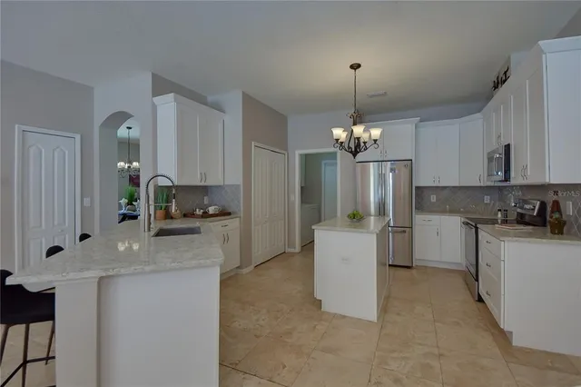 a kitchen with kitchen island granite countertop a stove a sink a center island and cabinets