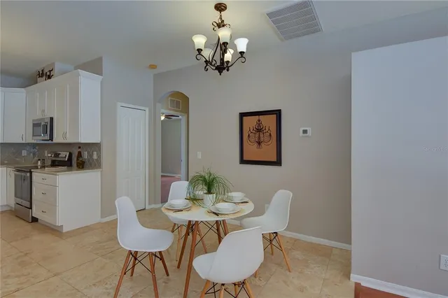a view of a dining room with furniture a chandelier and wooden floor