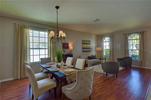 a view of a dining room with furniture a chandelier and wooden floor