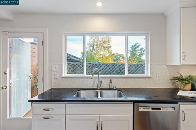 a kitchen with granite countertop a sink and a window