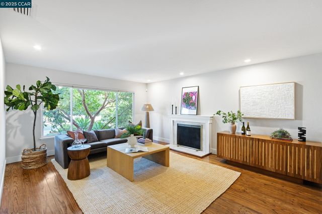 a living room with furniture fireplace and potted plants