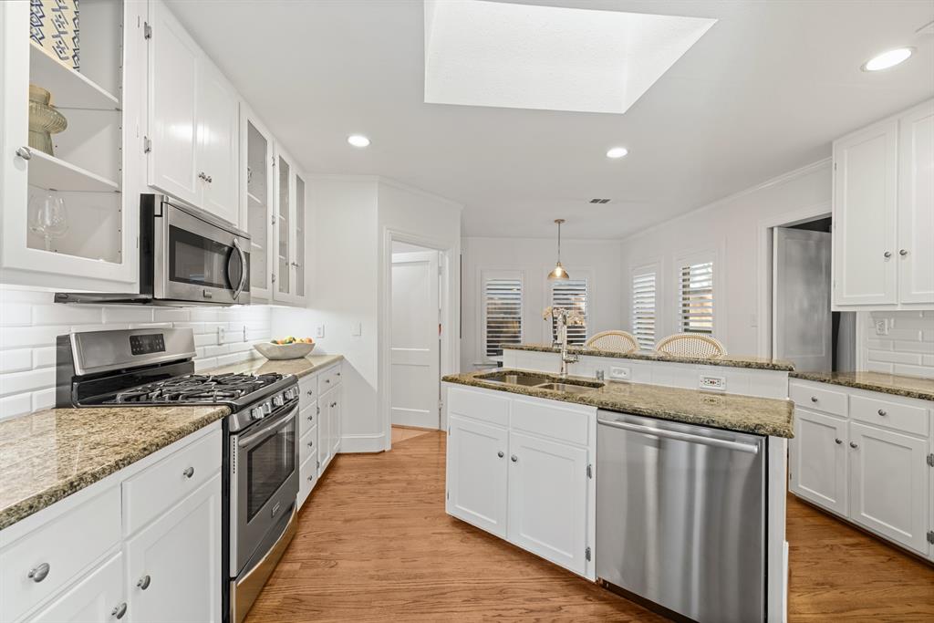 5242 Merrimac Avenue Dallas, TX 75206 - Photo 11 of 25 Kitchen with decorative backsplash, appliances with stainless steel finishes, white cabinetry, pendant lighting, and recessed lighting