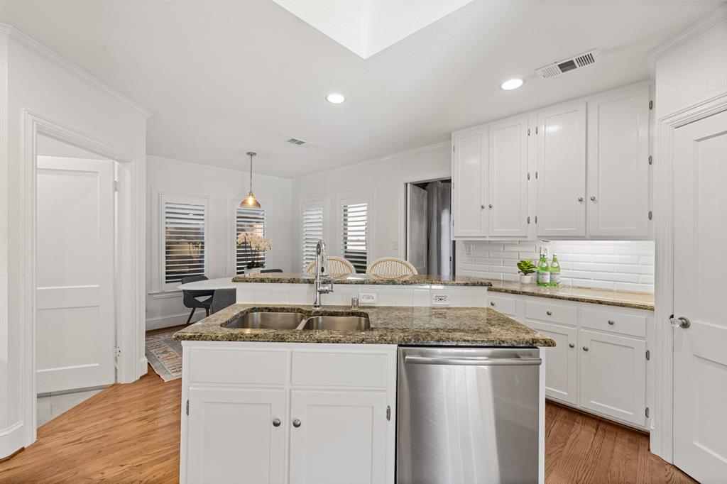 5242 Merrimac Avenue Dallas, TX 75206 - Photo 12 of 25 Kitchen featuring white cabinets, stainless steel dishwasher, light wood-style floors, recessed lighting, and ornamental molding