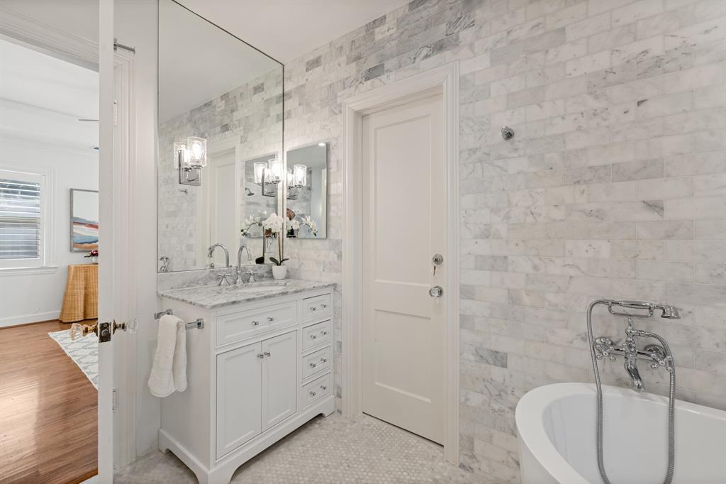 5242 Merrimac Avenue Dallas, TX 75206 - Photo 18 of 25 Full bath with vanity, a soaking tub, tile walls, and a chandelier