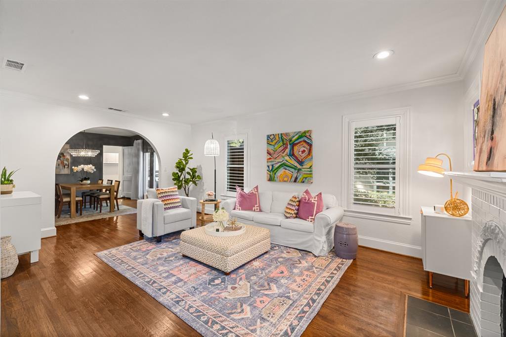 5242 Merrimac Avenue Dallas, TX 75206 - Photo 5 of 25 Living room featuring arched walkways, a fireplace, ornamental molding, recessed lighting, and dark wood finished floors