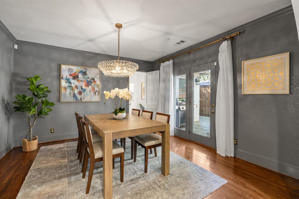 5242 Merrimac Avenue Dallas, TX 75206 - Photo 8 of 25 Dining area featuring ornamental molding, wood finished floors, a textured ceiling, and a chandelier