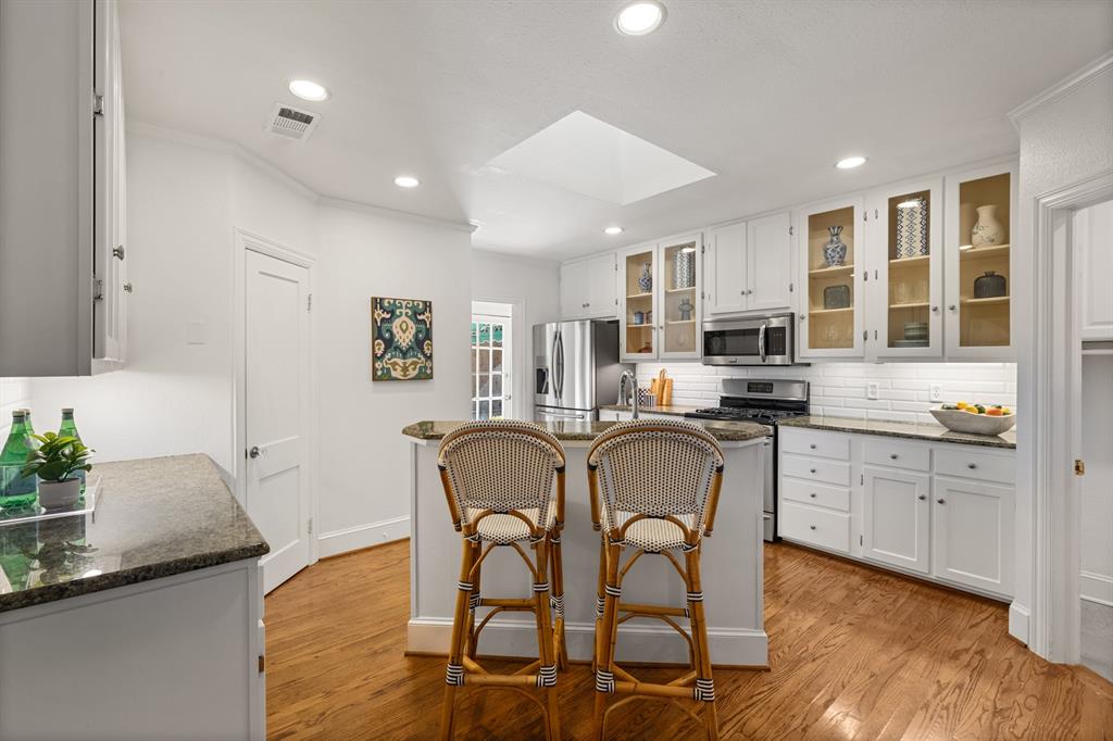 5242 Merrimac Avenue Dallas, TX 75206 - Photo 10 of 25 Kitchen with a skylight, white cabinetry, glass insert cabinets, decorative backsplash, and recessed lighting